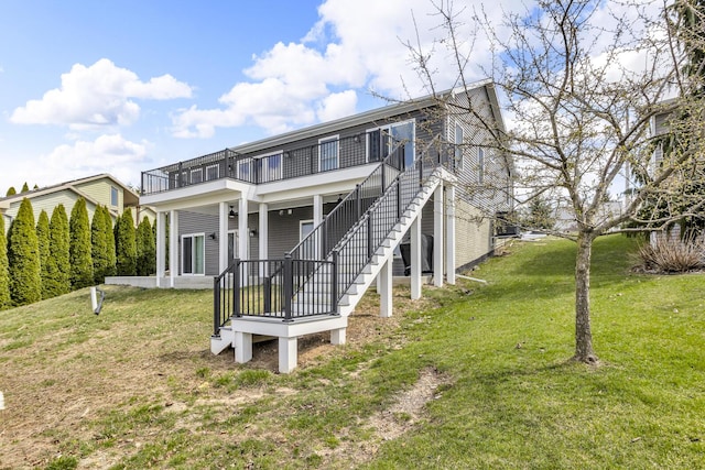 back of house with stairs and a yard