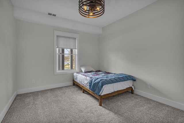 carpeted bedroom with visible vents and baseboards