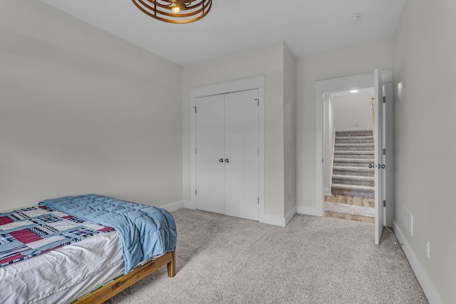 carpeted bedroom with baseboards and a closet