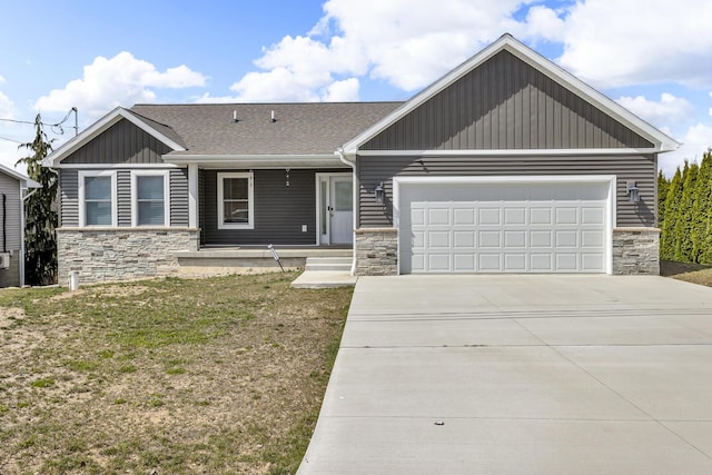 view of front of house featuring a front lawn, covered porch, stone siding, concrete driveway, and an attached garage