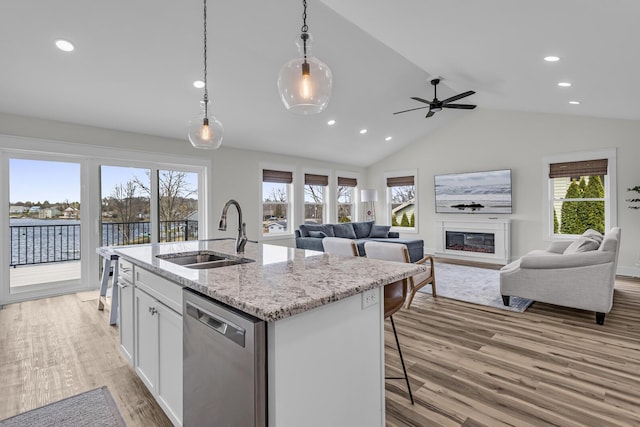 kitchen with a sink, light wood-style floors, recessed lighting, open floor plan, and stainless steel dishwasher