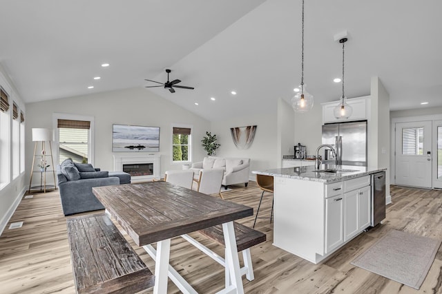 kitchen featuring a sink, a healthy amount of sunlight, open floor plan, and stainless steel appliances