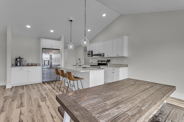 kitchen with light wood-style floors, white cabinets, stainless steel appliances, and a sink