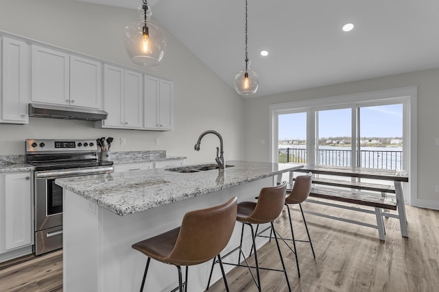 kitchen featuring stainless steel electric range oven, a sink, lofted ceiling, under cabinet range hood, and a water view