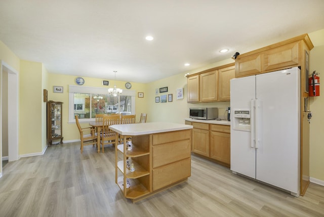 52473 Sheridan Rd, Paw Paw, MI 49079 - kitchen featuring white fridge with ice dispenser, stainless steel microwave, light wood-style floors, light countertops, and a center island