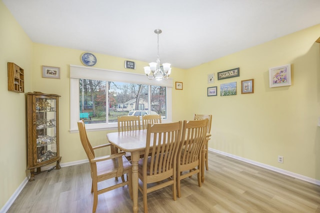 52473 Sheridan Rd, Paw Paw, MI 49079 - dining area with light wood finished floors, a chandelier, and baseboards