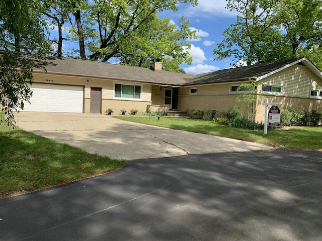 52473 Sheridan Rd, Paw Paw, MI 49079 - ranch-style house with a garage, driveway, a chimney, brick siding, and a front yard