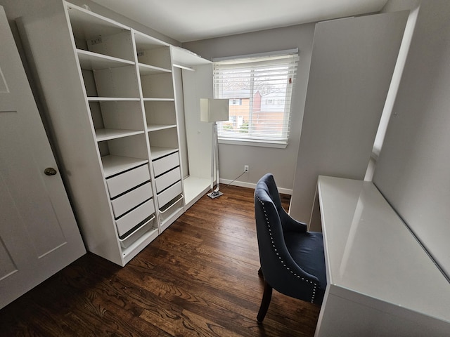 unfurnished office featuring baseboards and dark wood-type flooring