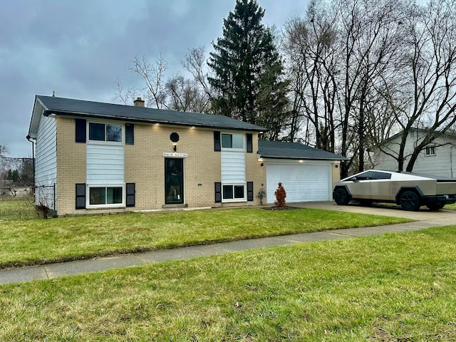 split foyer home with a front yard, an attached garage, a chimney, concrete driveway, and brick siding