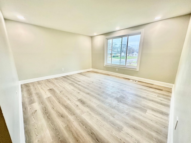 unfurnished room with wood finished floors, baseboards, visible vents, and recessed lighting