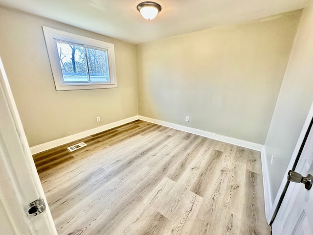 unfurnished room with visible vents, baseboards, and wood finished floors