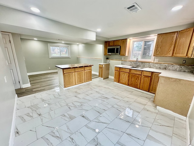 kitchen with stainless steel microwave, baseboards, recessed lighting, visible vents, and a sink