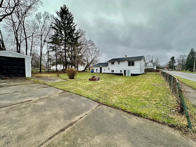 view of yard with fence and driveway