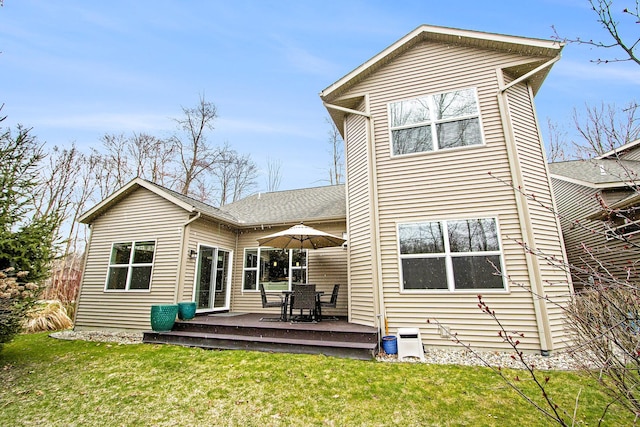 rear view of property with roof with shingles, a yard, and a wooden deck