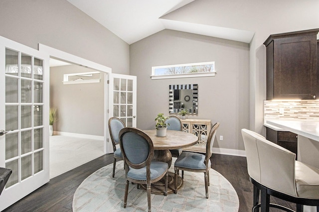 dining room featuring french doors, dark wood-style flooring, baseboards, and vaulted ceiling