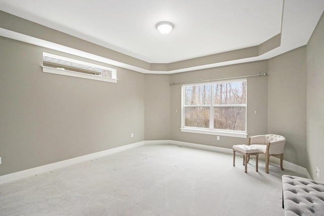 living area featuring baseboards, radiator, and light carpet