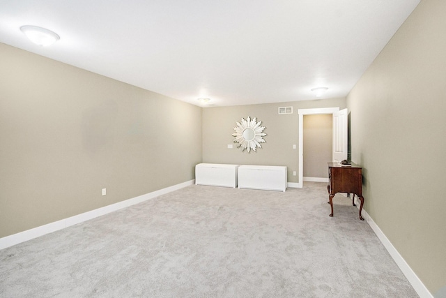 spare room with visible vents, baseboards, and light colored carpet