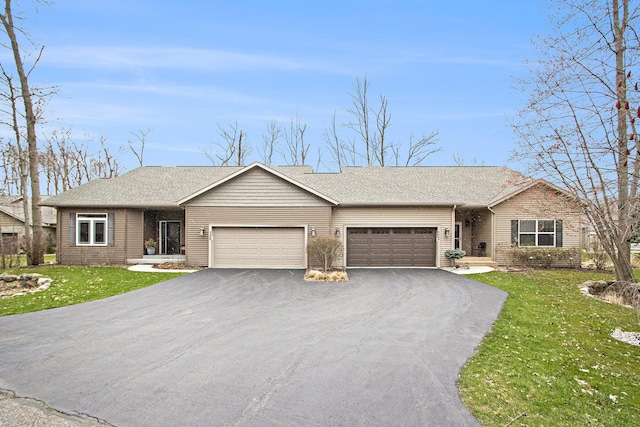 ranch-style house featuring roof with shingles, a garage, a front yard, and driveway