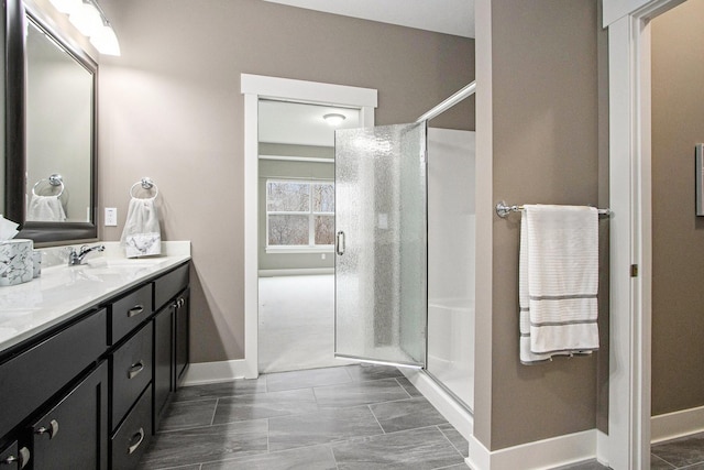 bathroom featuring baseboards, a shower stall, and vanity
