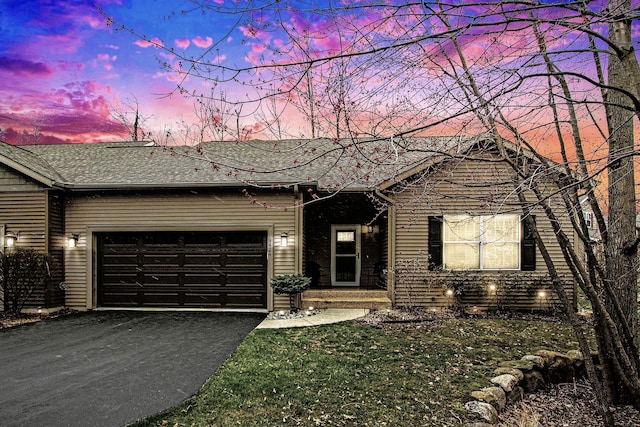 ranch-style home featuring a garage, roof with shingles, and driveway