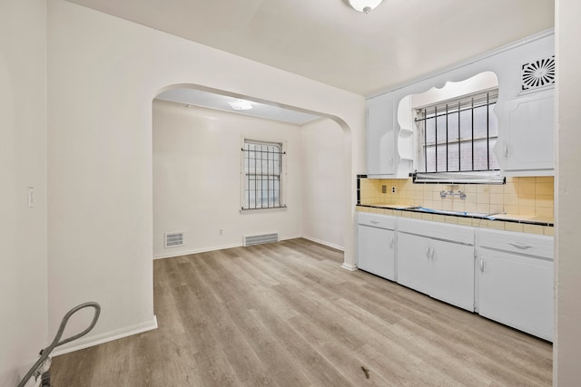 9233 Mckinney St, Detroit, MI 48224 - kitchen featuring light wood-style floors, arched walkways, and visible vents