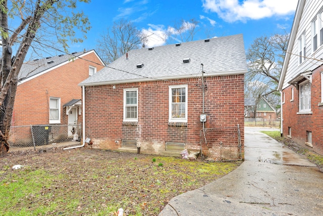 9233 Mckinney St, Detroit, MI 48224 - back of property featuring brick siding, driveway, fence, and a shingled roof