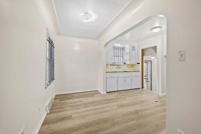 9233 Mckinney St, Detroit, MI 48224 - hall featuring visible vents, baseboards, light wood-type flooring, and arched walkways