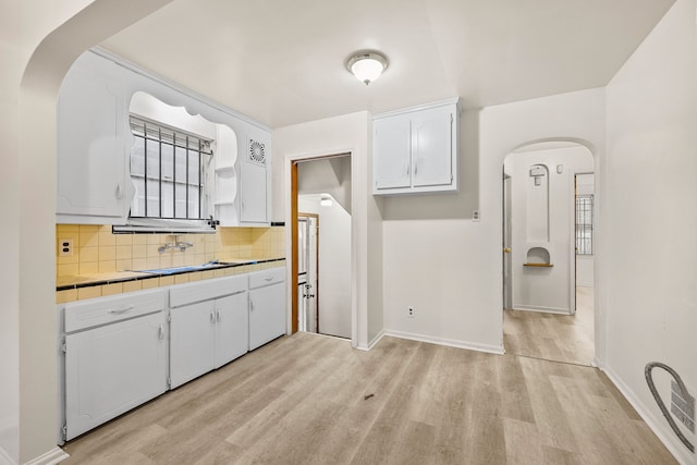 9233 Mckinney St, Detroit, MI 48224 - interior space with light wood-style flooring, white cabinetry, visible vents, a sink, and decorative backsplash