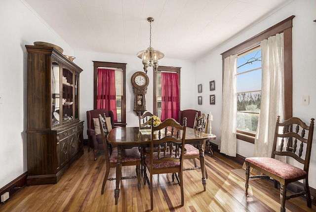 dining room featuring light wood-type flooring and an inviting chandelier