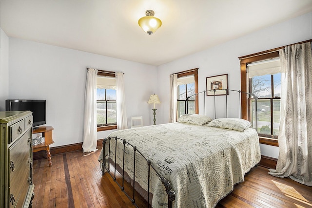 bedroom with baseboards and dark wood-type flooring