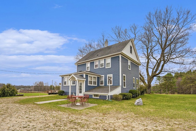 back of house featuring a yard, a shingled roof, and a chimney