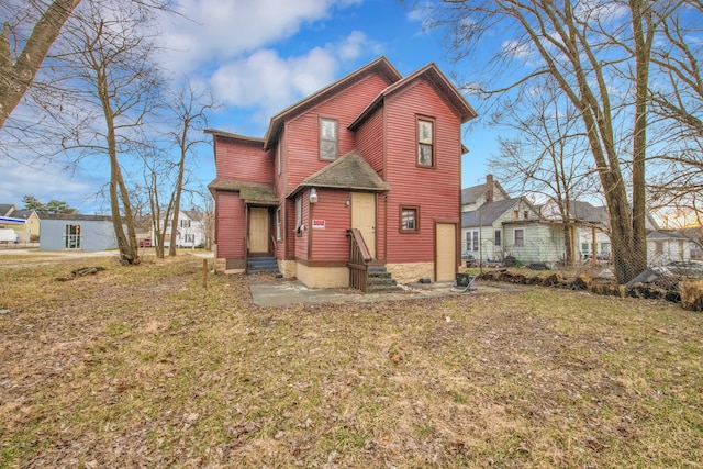view of front of home with entry steps and a front yard