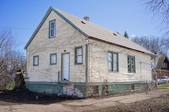 13057 Chelsea St, Detroit, MI 48213 - view of home's exterior with roof with shingles, fence, and a chimney