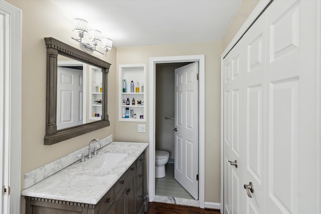bathroom featuring wood finished floors, toilet, and vanity