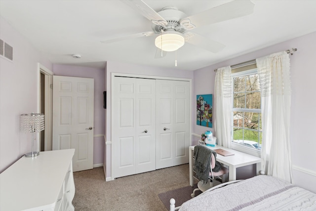 bedroom with visible vents, light carpet, ceiling fan, and a closet
