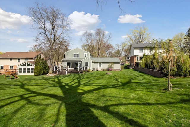 back of property featuring a deck and a yard