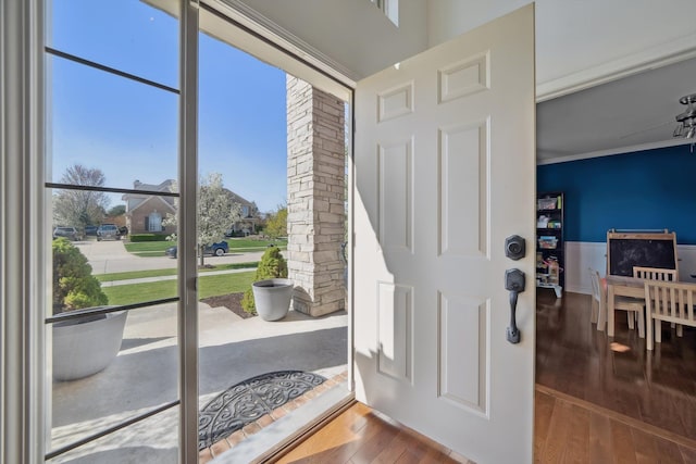 doorway with crown molding and hardwood / wood-style floors