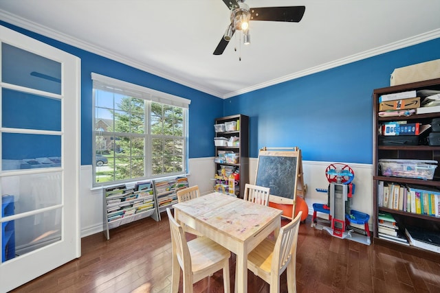 rec room with crown molding, a wainscoted wall, a ceiling fan, and hardwood / wood-style floors