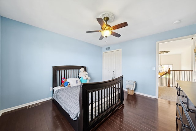 bedroom with a ceiling fan, visible vents, baseboards, wood-type flooring, and a closet