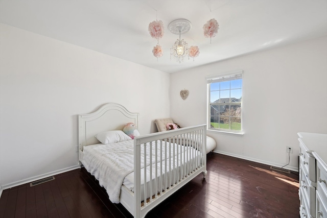 bedroom with baseboards, hardwood / wood-style flooring, and visible vents