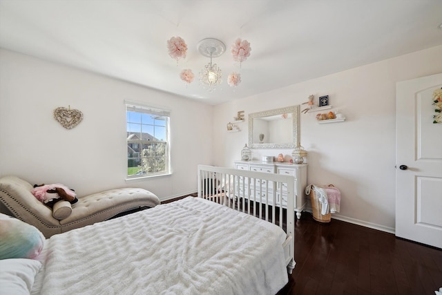 bedroom with wood-type flooring and baseboards