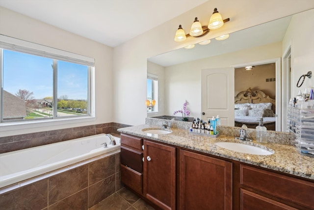 bathroom with a garden tub, a sink, ensuite bath, and double vanity