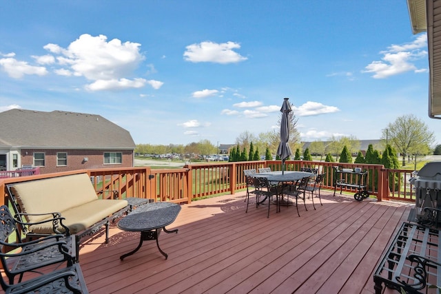wooden terrace with outdoor dining area and grilling area