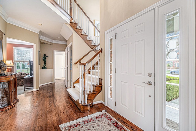foyer entrance featuring ornamental molding, stairs, dark wood-style flooring, and baseboards