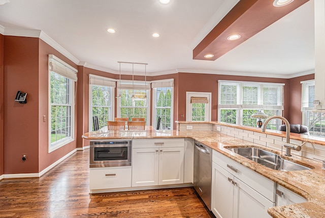 kitchen featuring ornamental molding, dishwasher, and a sink