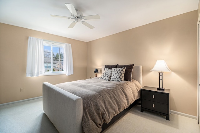bedroom with light colored carpet, ceiling fan, and baseboards