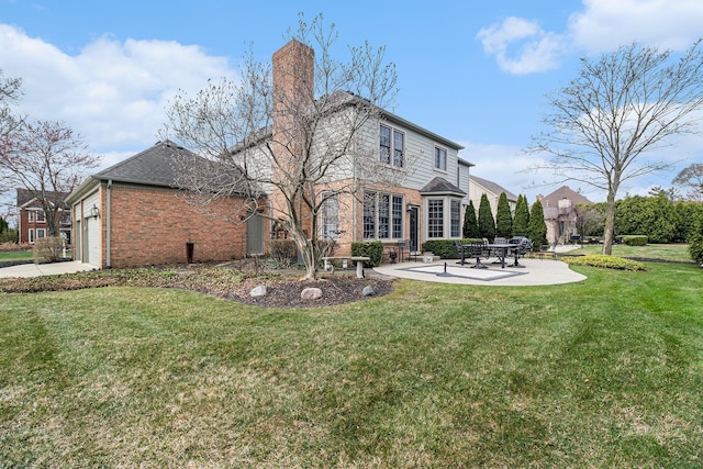 rear view of house featuring a chimney, a yard, brick siding, a patio area, and an attached garage