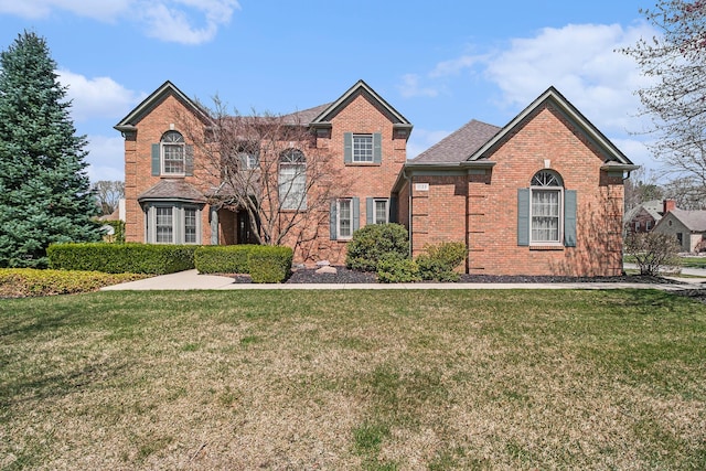 view of front of house with brick siding and a front lawn