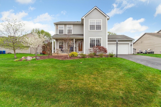 traditional-style home with a porch, a garage, aphalt driveway, and a front yard