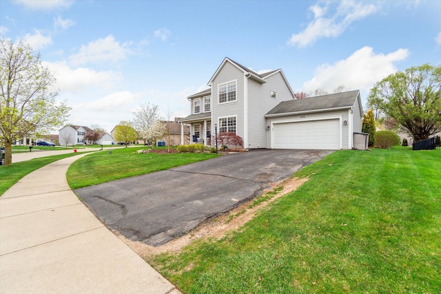 view of front of house with a garage, a front lawn, and aphalt driveway
